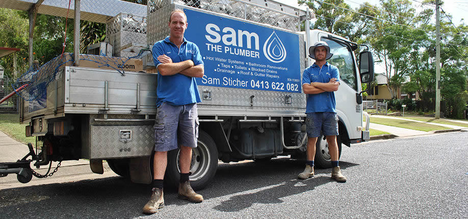Plumbing team standing in front of a service truck branded “Sam the Plumber” with tools and equipment, ready for residential plumbing work.